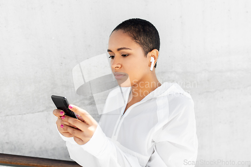 Image of african american woman with earphones and phone