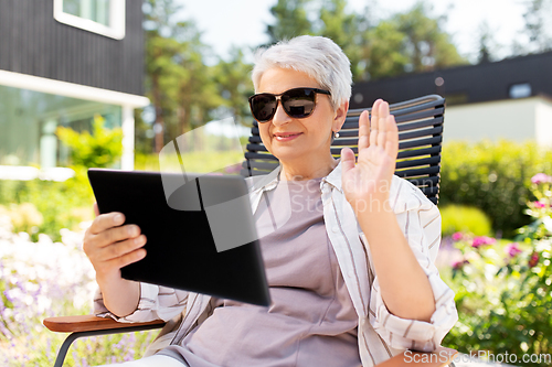 Image of happy senior woman with tablet pc at summer garden