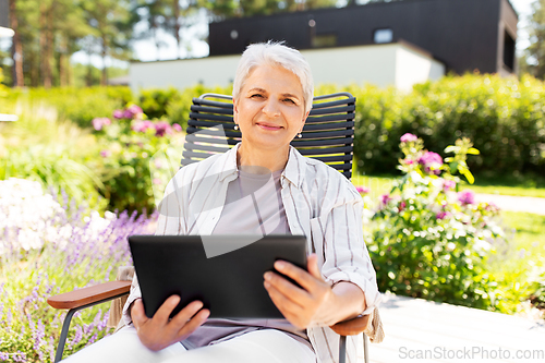 Image of happy senior woman with tablet pc at summer garden