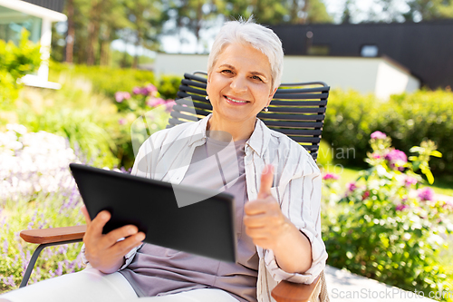 Image of happy senior woman with tablet pc at summer garden