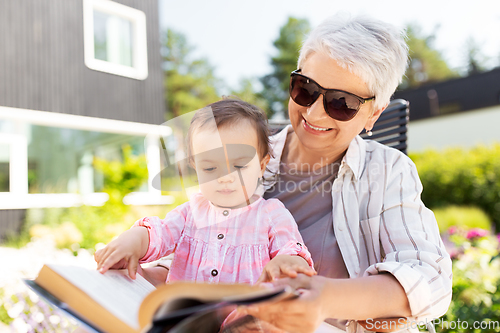 Image of grandmother and baby granddaughter reading book