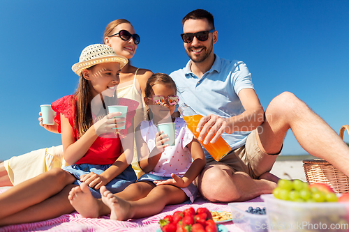 Image of happy family having picnic on summer beach