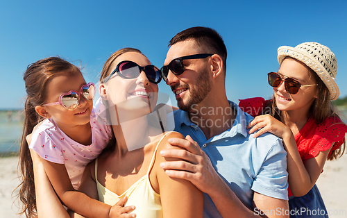 Image of happy family in sunglasses on summer beach