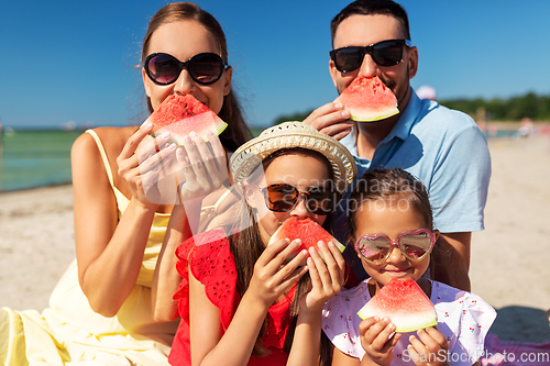 Image of happy family with watermelon on picnic on beach