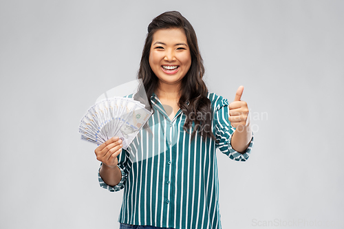 Image of asian woman with hundred dollar money banknotes