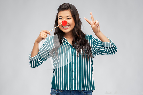 Image of happy asian woman with red clown nose