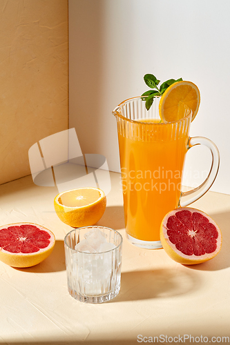 Image of orange juice, grapefruit and ice in glass on table