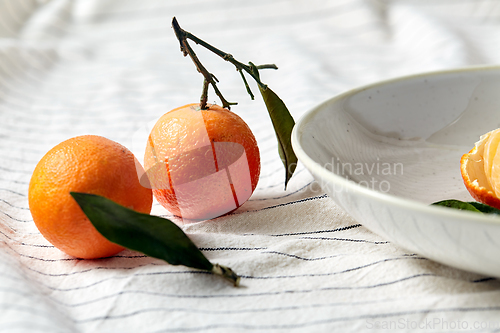 Image of still life with mandarins on plate over drapery