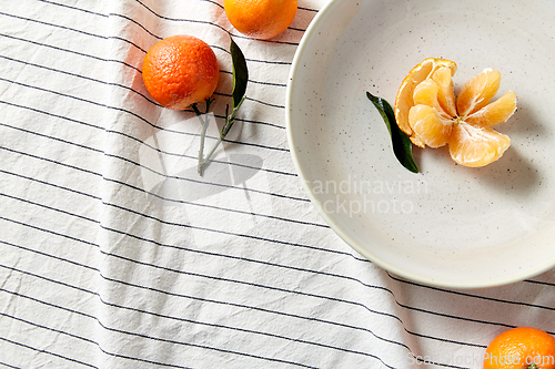 Image of still life with mandarins on plate over drapery