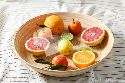 Image of close up of citrus fruits on wooden plate