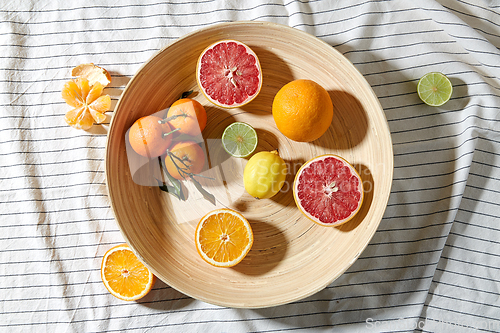 Image of close up of citrus fruits on wooden plate