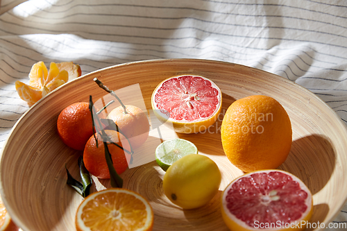 Image of close up of citrus fruits on wooden plate