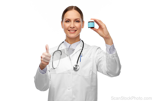 Image of smiling female doctor holding jar of medicine