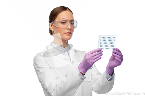 Image of female scientist in goggles with chemical sample