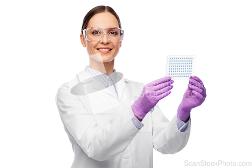 Image of female scientist in goggles with chemical sample