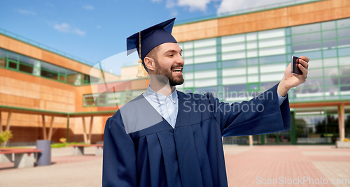 Image of male graduate student with smartphone takes selfie