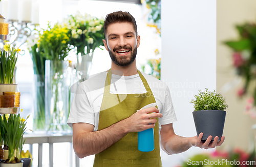 Image of happy smiling male seller moisturizing flower