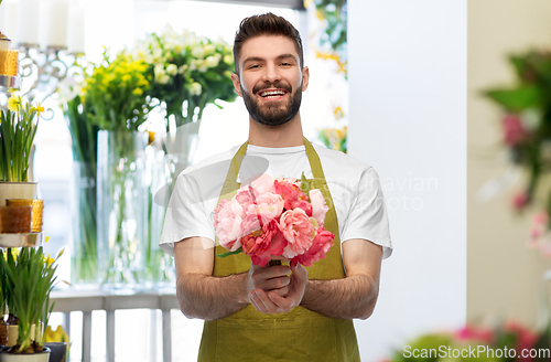 Image of smiling male seller with bunch of peony flowers