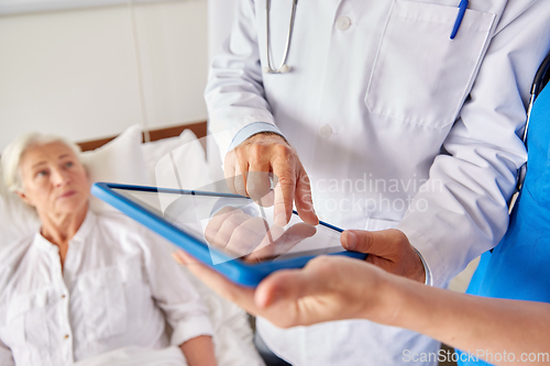 Image of doctors with table pc and senior woman at hospital