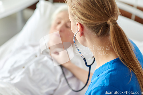 Image of doctor with stethoscope and old woman at hospital