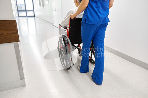 Image of nurse with senior patient in wheelchair at clinic