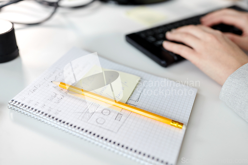 Image of businesswoman with notebook and computer at office