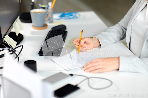 Image of businesswoman with notebook and computer at office