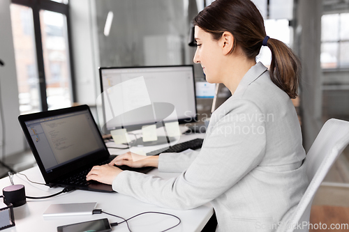 Image of businesswoman with laptop working at office