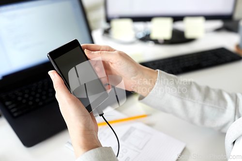 Image of businesswoman with smartphone working at office