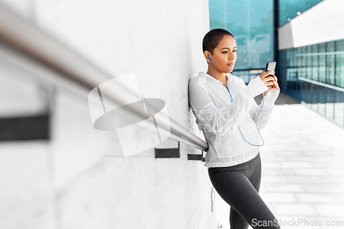 Image of african american woman with earphones and phone