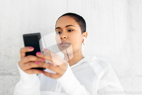 Image of african american woman with earphones and phone