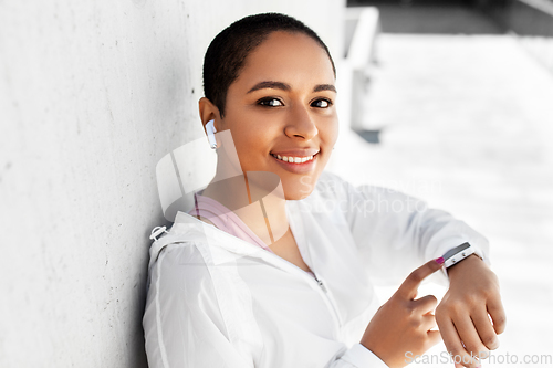 Image of african woman with earphones and smart watch