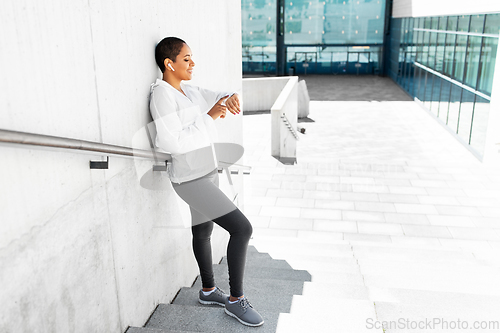 Image of african woman with earphones and smart watch