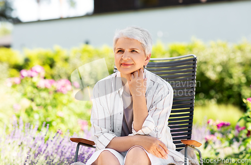 Image of happy senior woman resting at summer garden