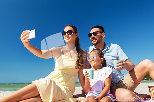 Image of happy family taking selfie on summer beach