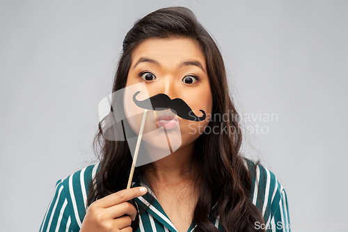 Image of asian woman with vintage moustaches party prop