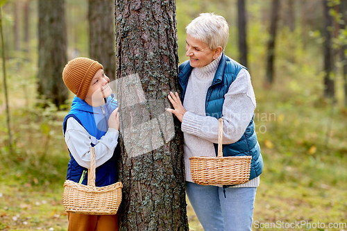 Image of grandmother and grandson with mushrooms in forest