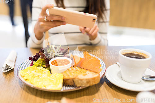 Image of Woman taking photo on her meal