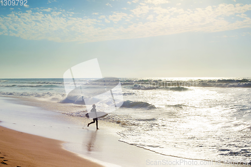 Image of Surfer running to surf