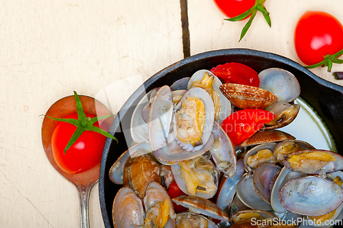 Image of fresh clams on an iron skillet