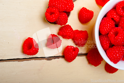 Image of bunch of fresh raspberry on a bowl and white table