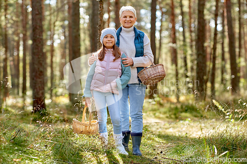 Image of grandmother and granddaughter picking mushrooms