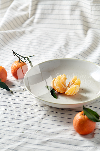 Image of still life with mandarins on plate over drapery