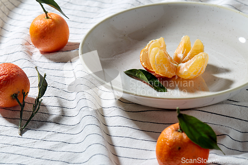 Image of still life with mandarins on plate over drapery