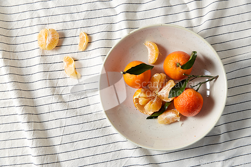 Image of still life with mandarins on plate over drapery