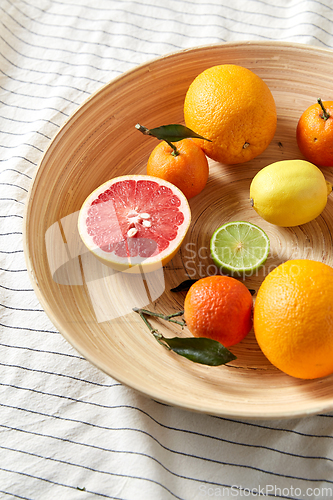 Image of close up of citrus fruits on wooden plate