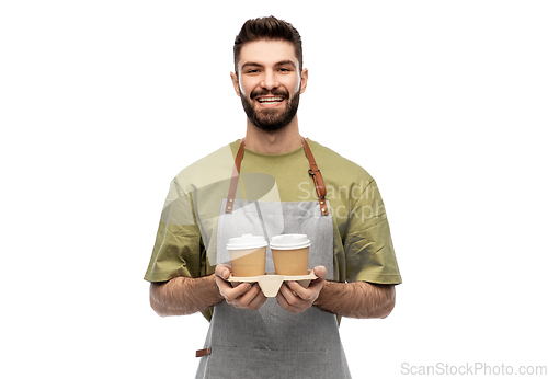 Image of happy smiling barman in apron with takeaway coffee