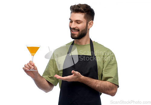 Image of happy barman in apron with glass of cocktail