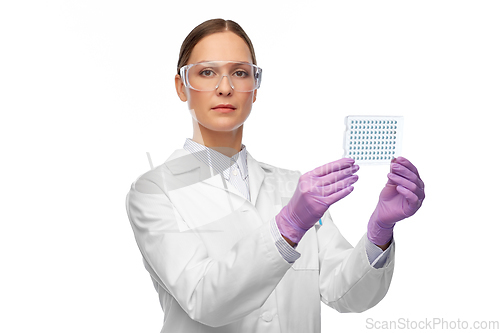 Image of female scientist in goggles with chemical sample