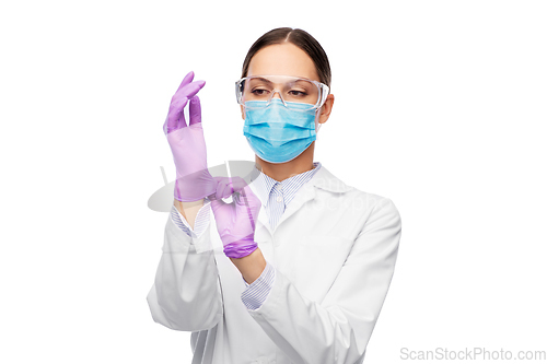 Image of female doctor in gloves, mask and goggles